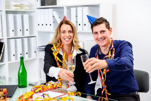 young businessman and businesswoman celebrating together in the office