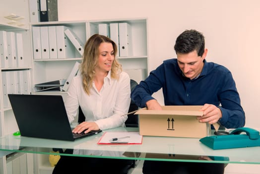 young businessman and businesswoman with delivery in the office