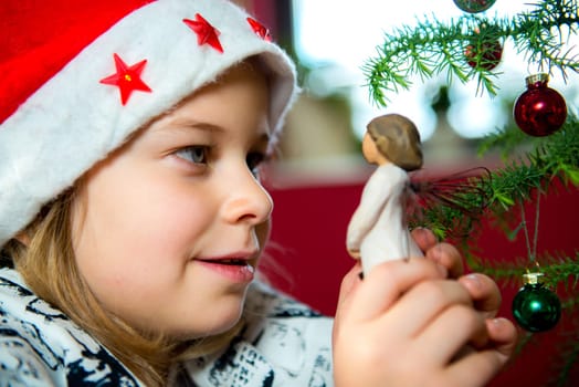 nice girl with Santa- cap and wooden angel