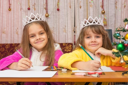 Two girls write wishes for the new year
