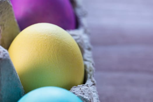 Colorful Easter eggs in egg carton.