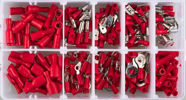 Red electric terminal connectors organized in plastic contaner.