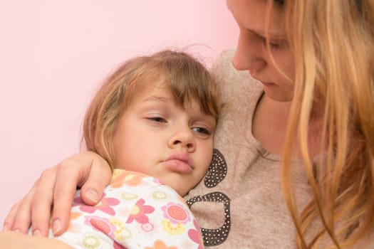 Sad five year old girl clung to her mother
