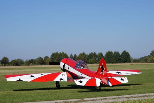 Single-engine red and white old sports aircraft