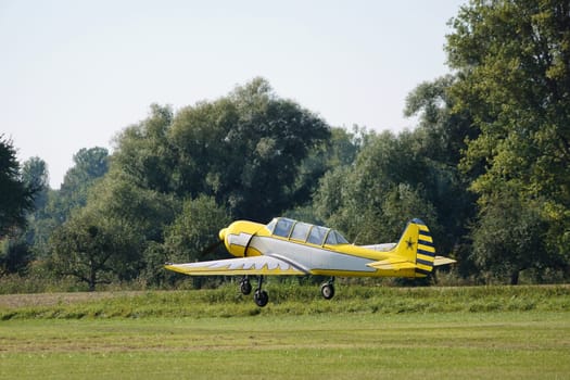 Launch of a single-engine yellow-white old sports aircraft