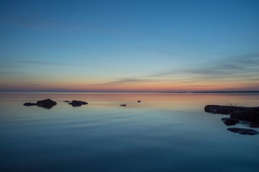 A few small ripples around the rock silhouettes makes this peach and blue image of the water and sky restful