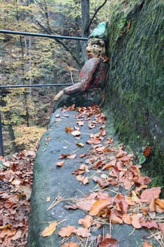 Dwarf sitting on the bench - rock relief from 1833