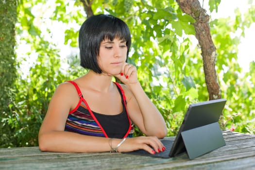 casual woman working with a tablet pc, outdoor
