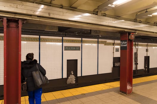 NEW YORK - APRIL 27, 2016: Unkknown traveler waiting for the subway to come on Fulton street subway platform