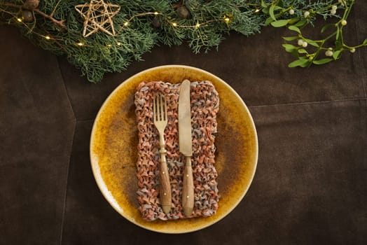 Christmas place setting with brown plate, mistletoe, fir green and fairy lights