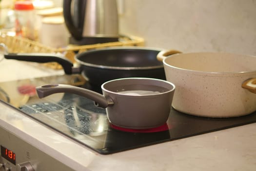 Water is heating in a small pot while other cookware is visible nearby.