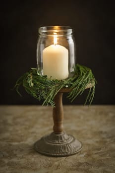 Christmas candle decoration with fir green and eucalyptus on a wooden stand