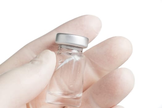 Hand with protective glove holding the medical vial
