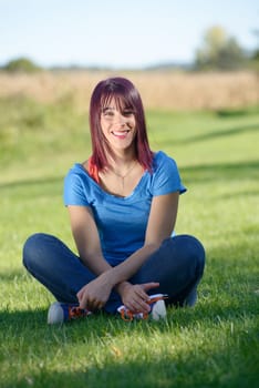 beautiful young woman sitting in the grass in the countryside