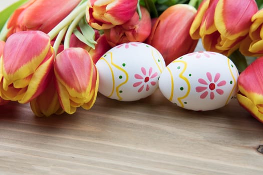 Painted Easter eggs and red and yellow tulips