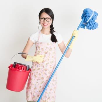 Young Asian housewife hand holding bucket and mop, doing house chores.