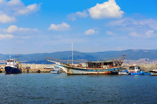 Nesebar, Bulgaria - August 30, 2013: Old ship, boats, yachts and launches, standing at the pier in the port of the old town of Nessebar, on the Black Sea coast. Sunny summer day.