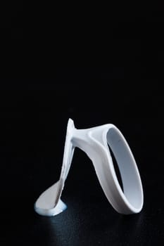 Close-up of a beverage cap with milk drops against a black background.