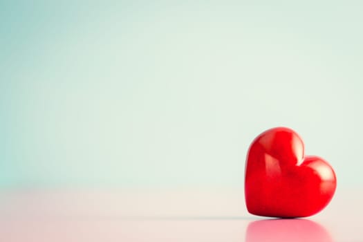 Red heart on pink table. Romance concept.