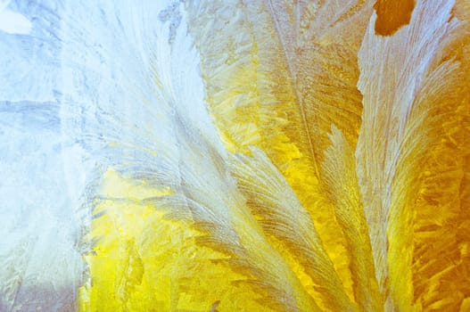 Melted and frosted ice pattern on frosty window glass in winter