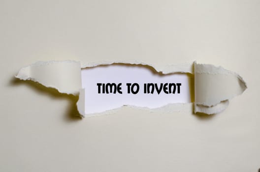 The word time to invent appearing behind torn paper