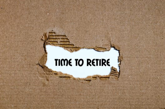 The word time to retire appearing behind torn paper