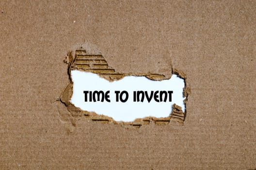 The word time to invent appearing behind torn paper