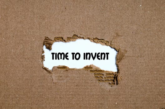 The word time to invent appearing behind torn paper