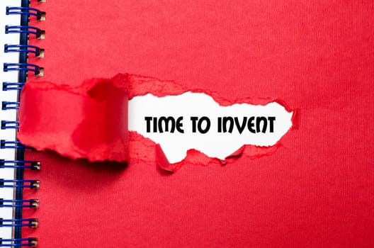 The word time to invent appearing behind torn paper