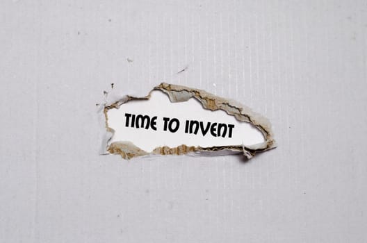The word time to invent appearing behind torn paper