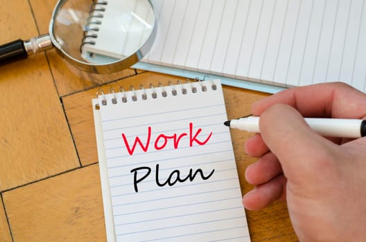 Human hand over wooden background and work plan text concept