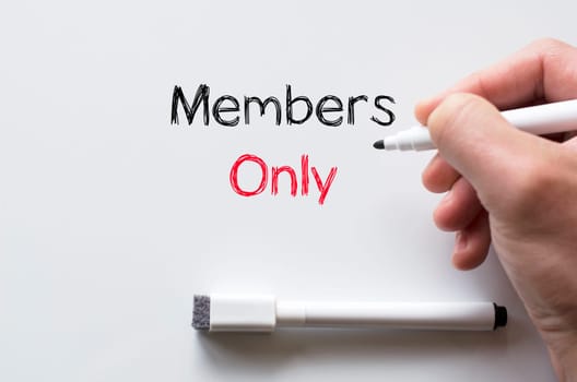 Human hand writing members only on whiteboard