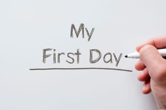 Human hand writing my first day on whiteboard