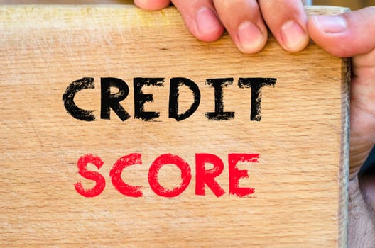 Human hand over wooden background and credit score text concept