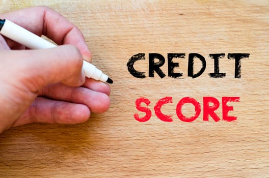 Human hand over wooden background and credit score text concept