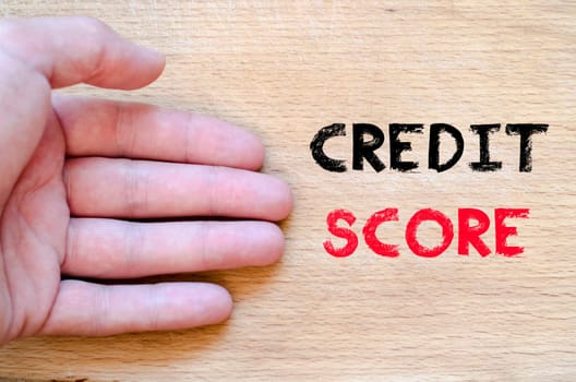 Human hand over wooden background and credit score text concept