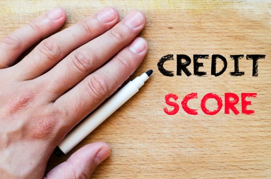 Human hand over wooden background and credit score text concept