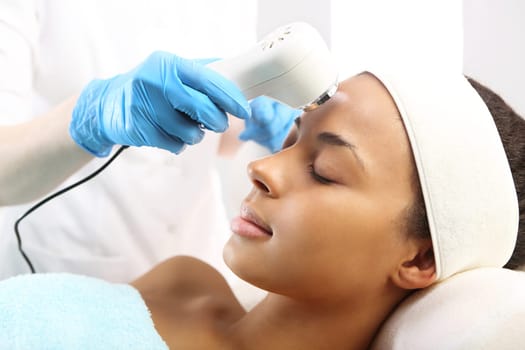 a woman's face during a treatment at a beauty salon\nultrasound infrared light,facial treatment\nultrasounds,a woman in a beauty salon\nlight therapy,a woman in a beauty salon\nacne treatment with light,a woman in a beauty salon