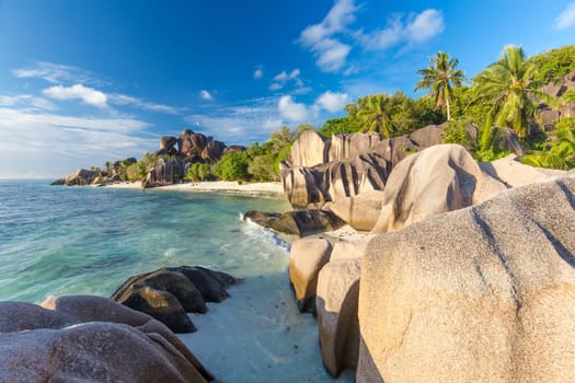 Beautifully shaped granite boulders in illuminated by summer sun on picture perfect tropical Anse Source d'Argent beach, La Digue island, Seychelles.