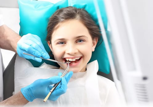 a child in a dental chair during a dental treatment. treatment of tooth loss,a child at the dentist. a dental office,a child in a dental chair. tooth treatment,the dentist cleans the cavity