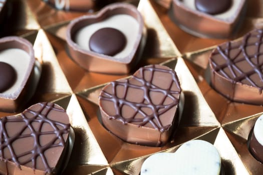 Close up of heart shaped chocolates in box.