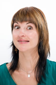 Head portrait of a young brunette woman against a white background,looking doubtfully anxiously into the camera.