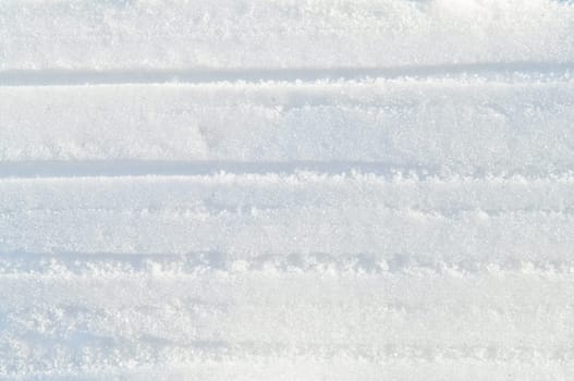 Winter snow background white snow flakes and crystals in natural light