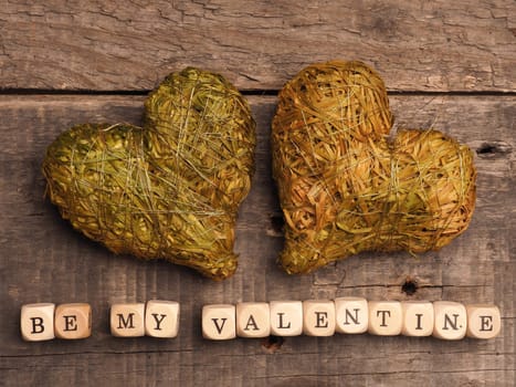 Wooden dices with heart shapes on a rustic wooden background, love concept image