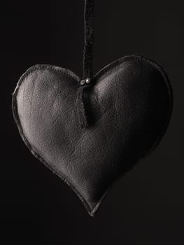 Love concept image with a black leather heart shape using as background or greeting card