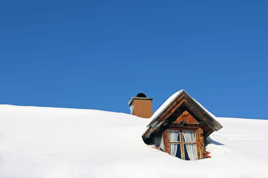 Lots of snow on a house roof. A snowy house roof with skylight