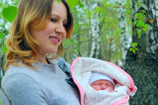 happy mother with her newborn baby in the spring