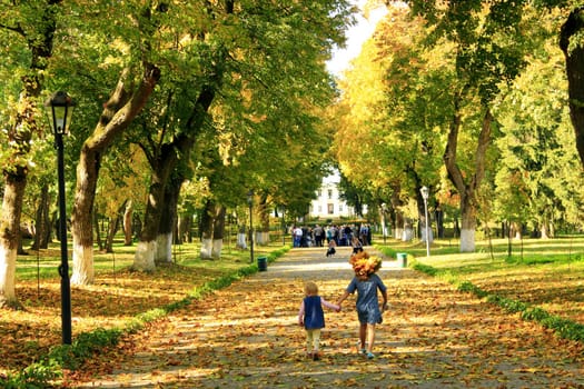 young happy sisters with cries wow run in the autumnal park