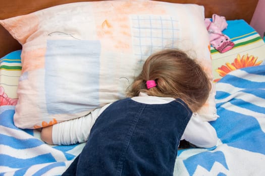 Five-year girl crying with his face buried in the pillow