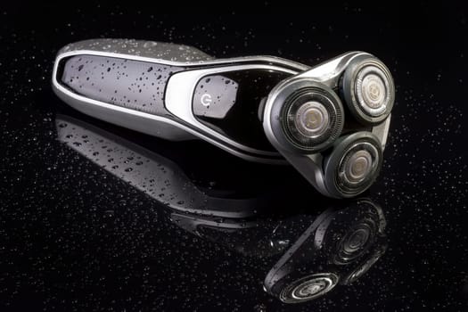 Electric shaver closeup on black background. Multi Precision text written on razor head! Best precision for shave!